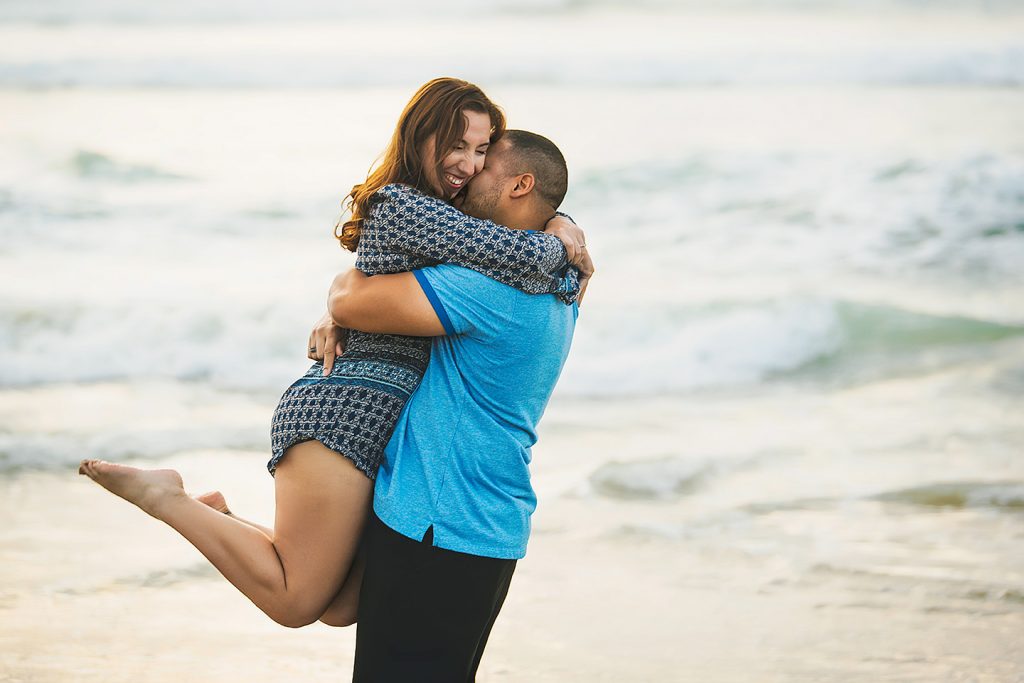 engaged couple embracing Mission Beach San Diego