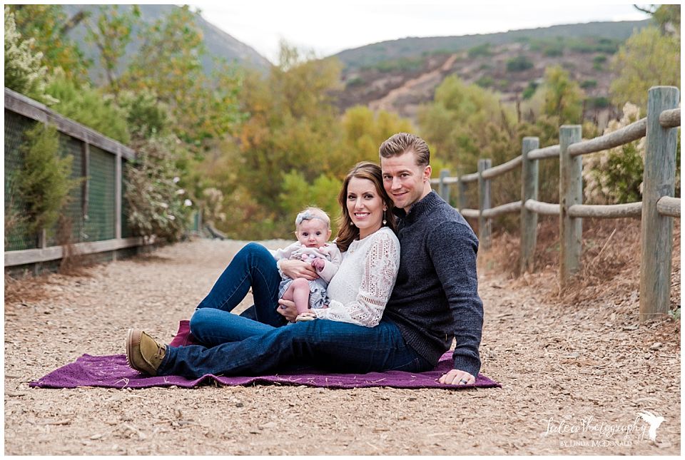 family of three sitting on blanket for san diego family portaits