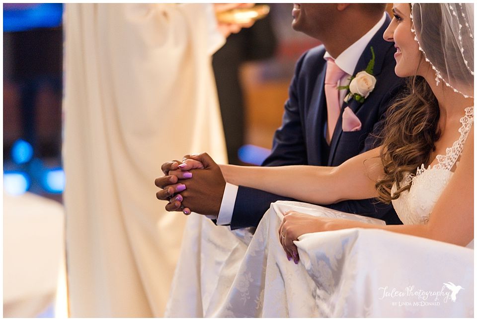 bride-groom-kneeling-holding-hands-catholic-wedding-ceremony