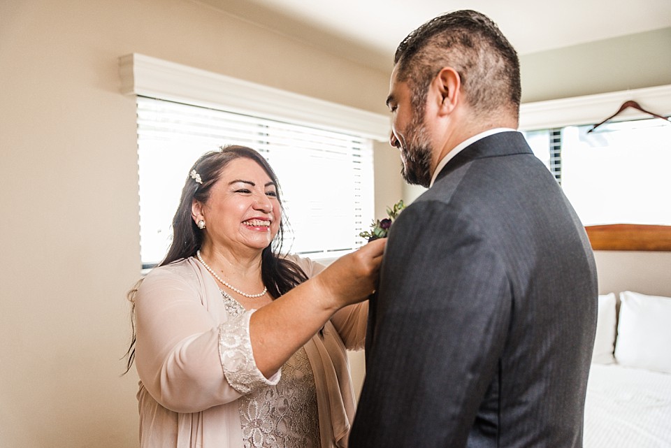 grooms mom putting on boutonniere 