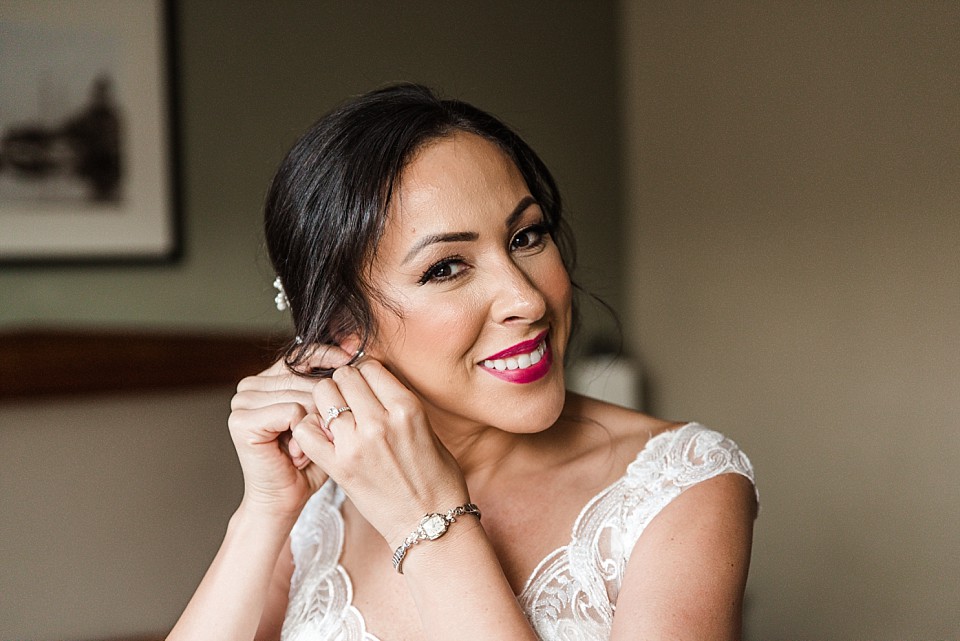 beautiful bride putting on her earrings Coronado hotel suite
