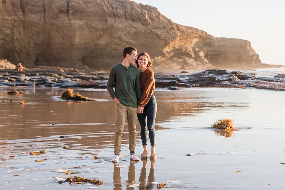 couple posing on the beach engagement photos at sunset cliffs
