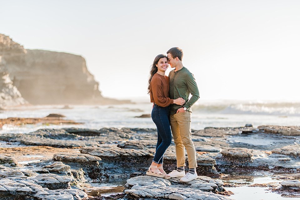 guy snuggling close while girl looks on san diego engagement photos romantic