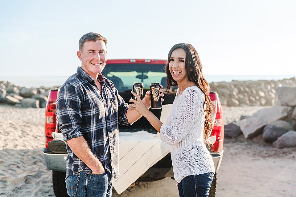 couple toasting Guinness beer san diego beach engagement photos