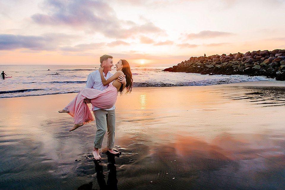 engagement photos san diego guy carrying girl into sunset