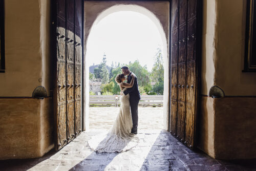 couple backlit standing in door at Mission de Alcala wedding San Diego
