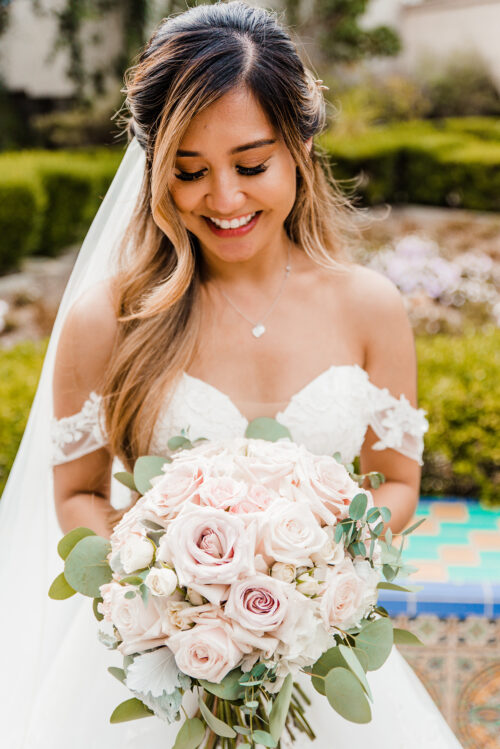 filipino bride smiling at bouquet