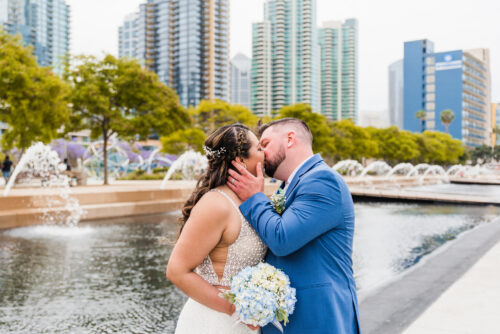 Couple kissing in front of fountains at San Diego WaterfrontPark