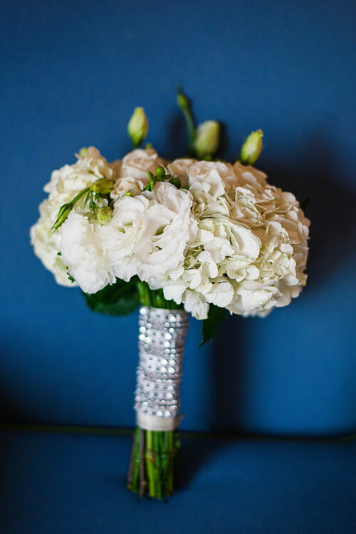 white bouquet propped up on blue chair