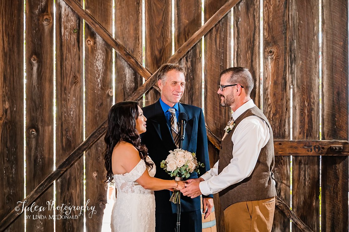 bride and groom facing each other in Bernardo Winery barn wedding ceremony